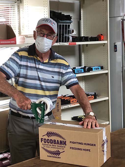 Honorary Rotarian takes time out to seal the packed Foodbank boxes ready for distribution