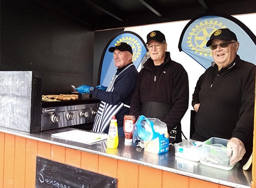 Rotary members feeding customers at a BBQ raising funds in support of the Good Night Sleep Tight Charitable Trust